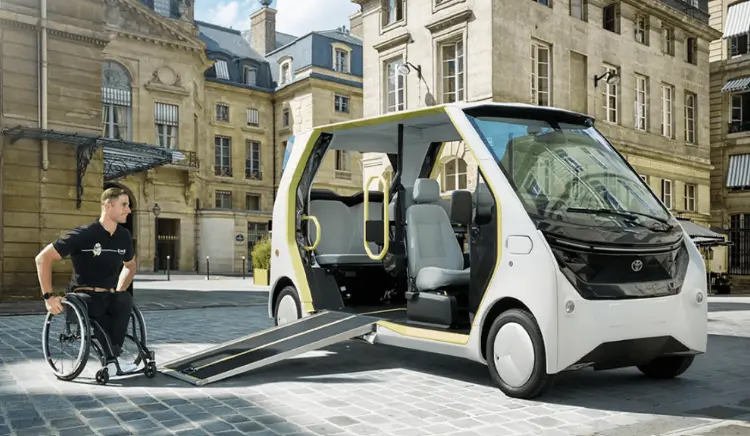 Toyota APM com rampa de acesso aberta para utilizador de cadeira de rodas, numa rua de Paris
