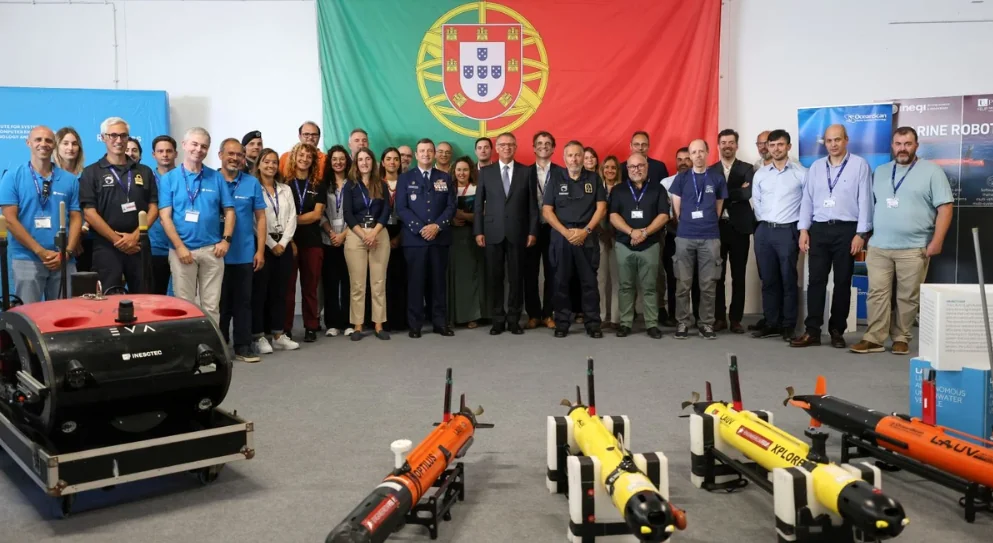 Grupo de participantes del REPMUS 2026 ante la bandera portuguesa, con sistemas no tripulados en primer plano